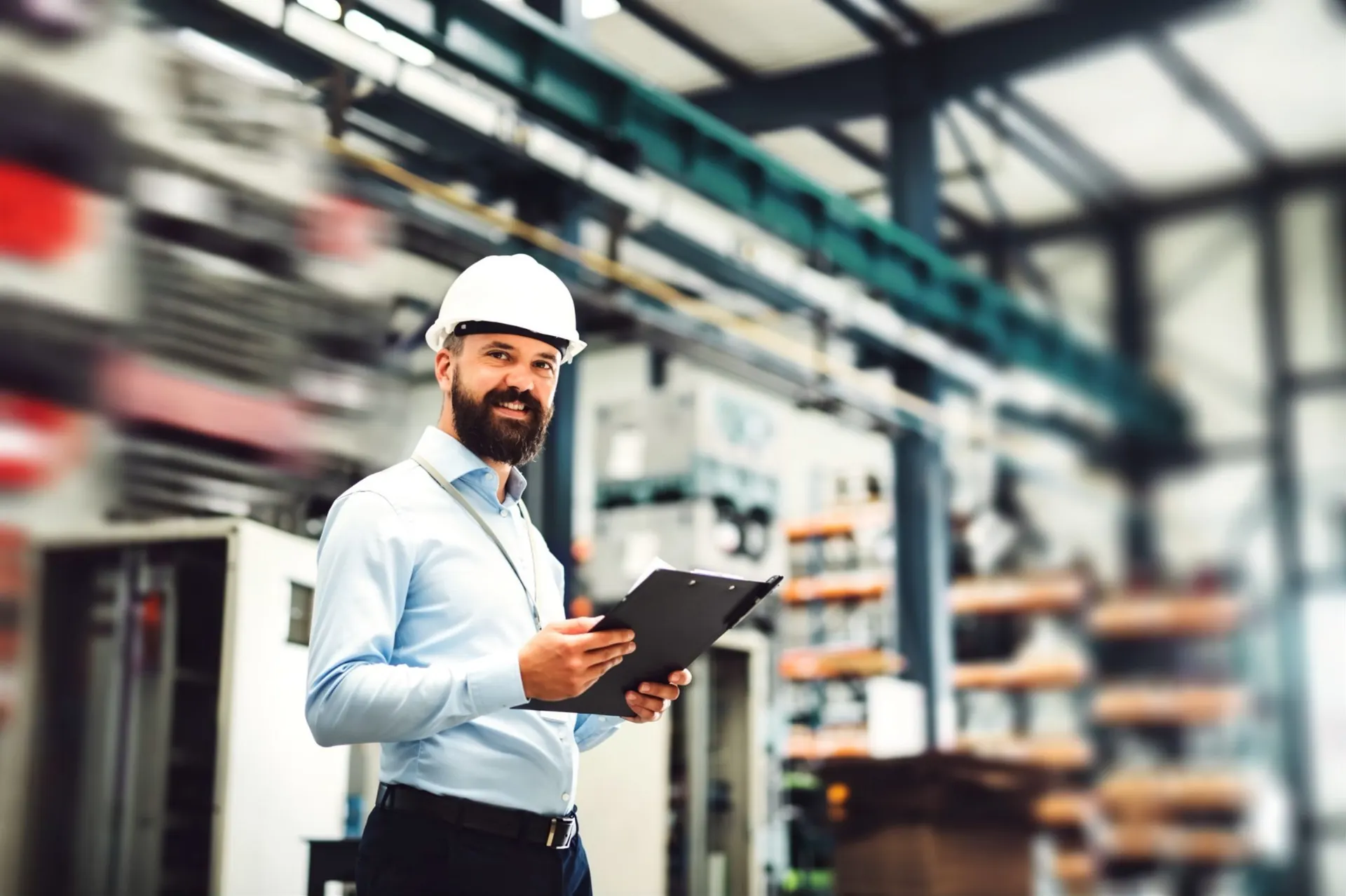 Engineer with documents in an industrial equipment warehouse